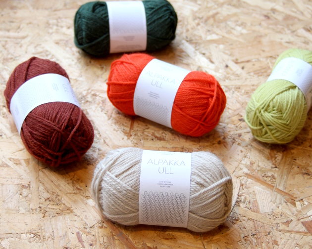 Five balls of alpakka ull in cream, bright red, burgundy, lime green and petrol